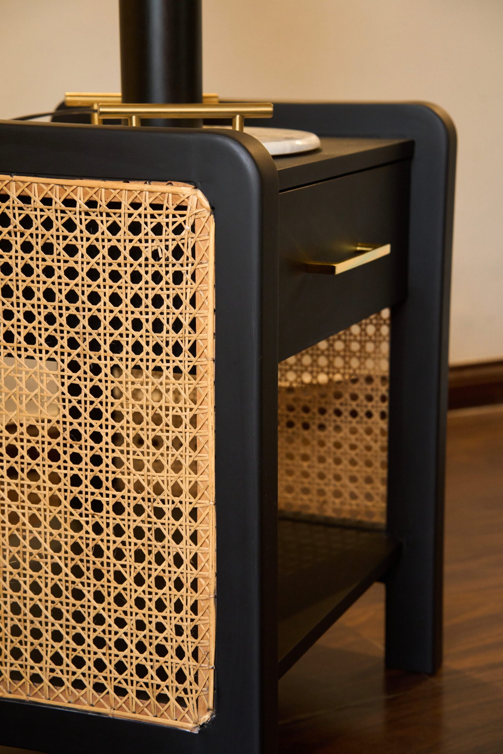 Black cane bedside table styled in a refined interior